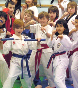 Group of children in various taekwondo poses at Transcending Martial Arts
